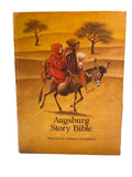 Cover of the Augsburg Story Bible illustrated by Annegert Fuchshuber, featuring an illustration of a person on a donkey in a desert-like setting.